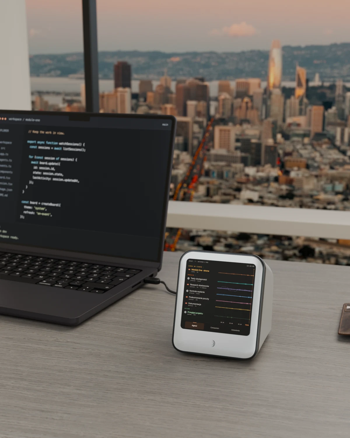 Module One z ekranem agentów obok MacBooka na biurku, widok na San Francisco